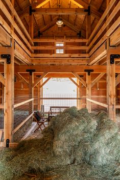 the inside of a barn with hay in it