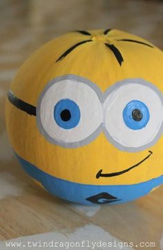 a yellow and blue ball with googly eyes sitting on top of a wooden table