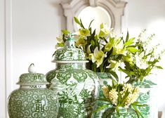 green and white vases with flowers in them