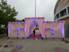 a man standing in front of a pink and white stage set up for a wedding