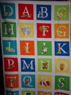 a child's blanket that has letters and animals on it, all in different colors