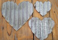 three heart shaped metal pieces sitting on top of a wooden floor