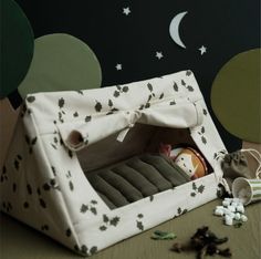 a small dog bed in the shape of a tent with stars and moon on it