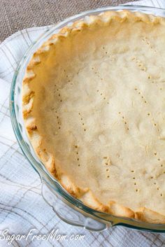 an uncooked pie sitting on top of a table next to a white towel