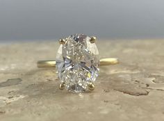 an oval cut diamond sits on top of a stone