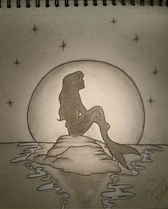 a drawing of a mermaid sitting on top of a rock