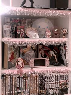 a book shelf filled with lots of books and dolls on top of it's shelves