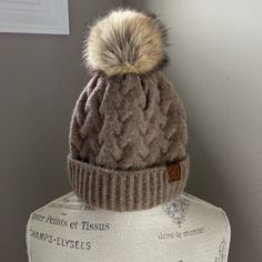 New Without Tags. Perfect Condition. Tan Color, Faux Fur Ball On Top. Classic Style. Fitted Brown Hats For Cold Weather, Fitted Brown Hat For Cold Weather, Winter Hat, Tan Color, Classic Style, Faux Fur, Winter Hats, Women Accessories, Tags