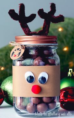 a glass jar filled with chocolate covered candies and a reindeer head sticking out of it