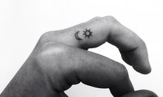 a hand with a small star and moon tattoo on it