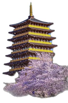 a tall building with trees in front of it and purple flowers growing on the ground