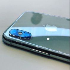 an iphone is sitting on a table with its back facing the camera and it's blue buttons