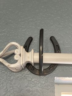 a pair of black and white scissors sitting on top of a gray counter next to a window