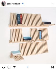 three bookshelves made out of wooden slats on a white wall with blue books