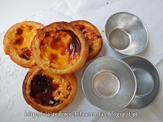 several small pies are sitting next to each other on a white tablecloth with silver dishes