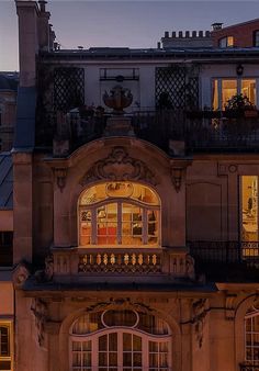 an old building with many windows and balconies lit up at night in the evening