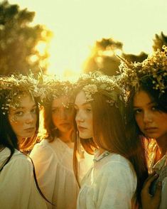 four beautiful young women with flower crowns on their heads