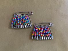 two pairs of colorful beaded earrings sitting on top of a table next to each other