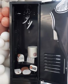 a black locker with white balloons and other items in the background, as well as an image of a basketball jersey on it