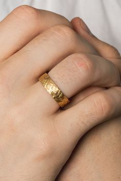 a close up of a person wearing a gold ring