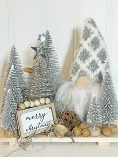 a christmas mantel with silver trees and ornaments