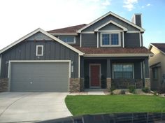 a gray house with two garages in the front and one on the other side