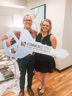 a man and woman holding up a sign