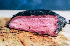 a piece of meat sitting on top of a wooden cutting board