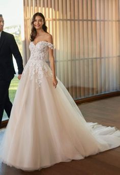 a woman in a wedding dress standing next to a man