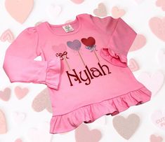 This personalized embroidered lollipop shirt is perfect for your sweet little girl! It is 100% cotton and 100% cute! It comes in sizes 12month to 6 in your choice of pink or red. Don't miss the opportunity for your sweetheart to display all this cuteness! Pink Long Sleeve Top For Birthday, Personalized Cute Cotton Shirt, Cute Long Sleeve Birthday Shirt, Pink Long Sleeve Top Suitable For Gifting, Pink Long Sleeve Top As A Gift, Embroidered Pink Tops For Birthday, Pink Embroidered Top For Birthday Party, Pink Embroidered Top For Birthday, Cute Long Sleeve Tops As Gift