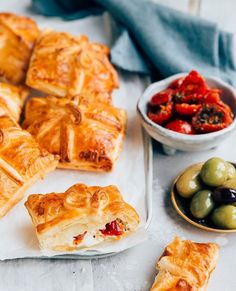 several different types of pastries and olives on a table