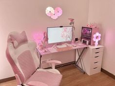 a desk with a computer, keyboard and pink chair in front of a heart shaped mirror