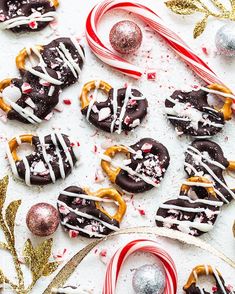 christmas cookies and candy canes laid out on a white surface with holiday decorations around them