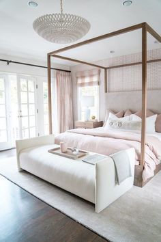 a bedroom with a canopy bed and white furniture