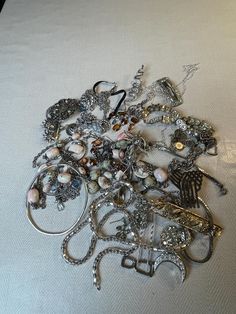 This is a 1/2 pound lot of broken and not, vintage and newer craft jewelry. The majority of these are wearable or for craft Silver tones There are necklaces, earrings, bracelets, key rings, broken pieces etc etc. Both vintage and modern. Perfect for your slow stitches or scrapbooking projects. Or other works of art This is NOT a mystery bag or box, so there will be no surprises You get everything in the picture. So study the pictures carefully !! Various materials such as plastic, metal, beads, Unique Party Jewelry With Charms, Elegant Assorted Jewelry For Gift, Vintage Charms For Crafting Jewelry, Vintage Handmade Assorted Jewelry, Vintage Silver Jewelry With Unique Variations, Assorted Jewelry Making Supplies, Handmade Vintage Jewelry In Assorted Colors, Assorted Vintage Handmade Jewelry, Handmade Assorted Jewelry In Various Shapes