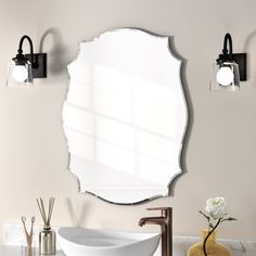 a bathroom sink sitting under a mirror next to a faucet mounted on a wall