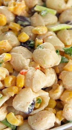 a white bowl filled with corn and chicken salad on top of a wooden cutting board