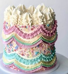 a multi layered cake with frosting on top and sprinkles around the edges