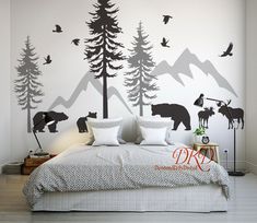 a bedroom with mountains, trees and animals painted on the wall