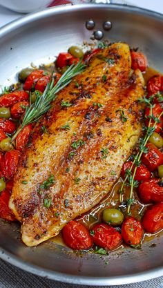 a close up of a plate of food with meat and tomatoes on it, including olives