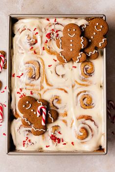 gingerbread roll with icing and candy canes in a baking pan on a table