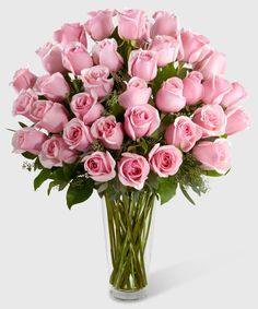 a vase filled with pink roses on top of a table