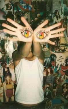 a person holding their hands up in the air with two eyes painted on each hand