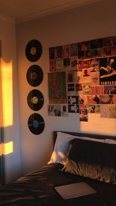 a bed sitting in a bedroom next to a wall with records on it