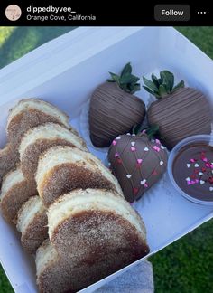 chocolate covered strawberries and pastries in a box on the grass with sprinkles