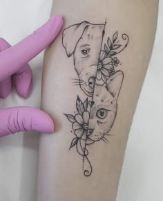 a cat and dog tattoo on the right thigh, with flowers around its leg area