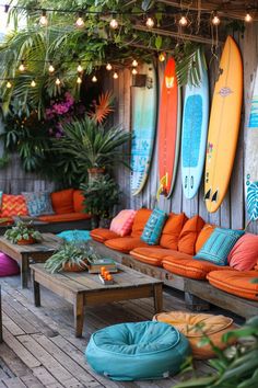 an outdoor seating area with surfboards on the wall and lights strung from the ceiling