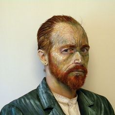 a close up of a person wearing a suit and tie with paint on his face