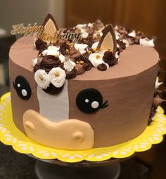 a chocolate cake decorated with flowers and a cow face