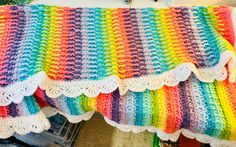 a multicolored crocheted blanket on top of a table